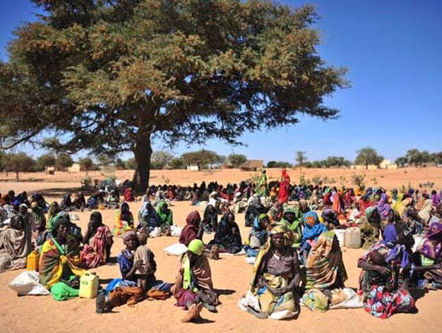 Mujeres sudanesas sentadas a la espera de que las organizaciones internacionales de ayuda humanitaria distribuyan alimentos en el poblado de Silea - Lynsey Addario