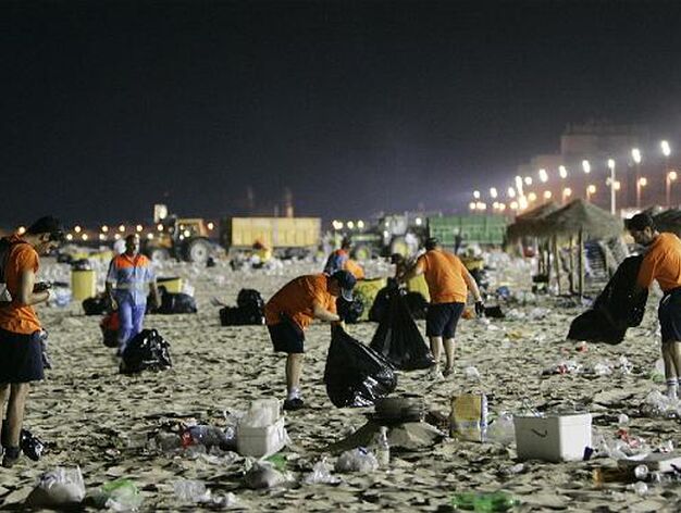 El equipo de limpieza trabaja a destajo para dejar la playa limpia para los primeros ba&ntilde;istas. 

Foto: Lourdes de Vicente