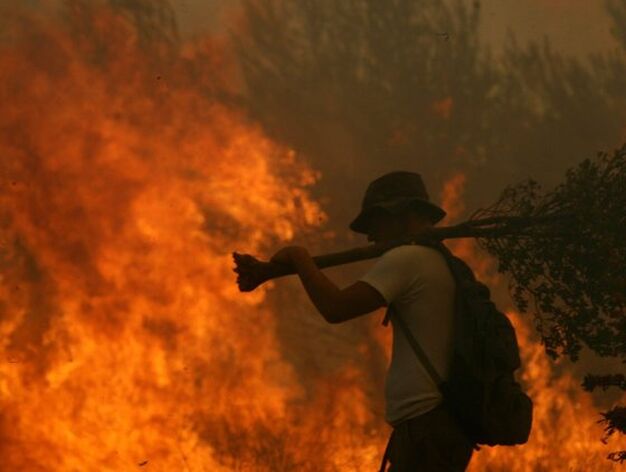 Los voluntarios y bomberos luchan contra el incendio forestal mientras 15.000 personas ya han abandonado sus casas en la zona.

Foto: Efe