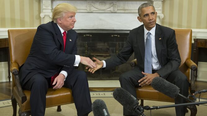 Trump y Obama se estrechan la mano.