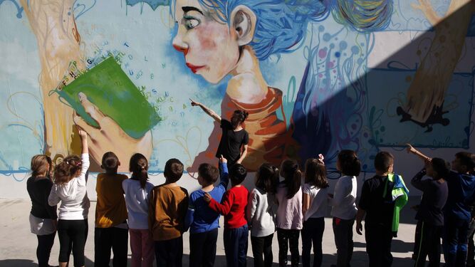 Chencho Aguilera muestra su mural a los alumnos del colegio Moreno Chacón de Ayamonte.