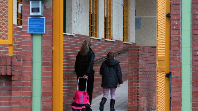 Una madre acompaña a su hija a la entrada del colegio El Puntal.
