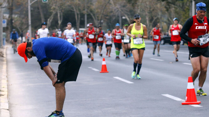 Un corredor con problemas en sus piernas se detiene en la Maratón de Santiago de Chile.