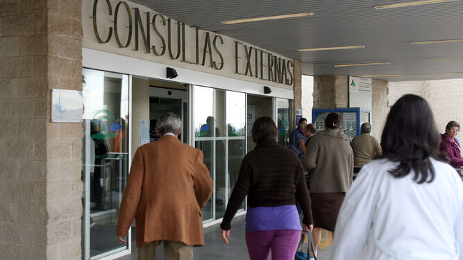 Varios usuarios y una profesional acceden a la zona de Consultas Externas en el Hospital Juan Ramón Jiménez.