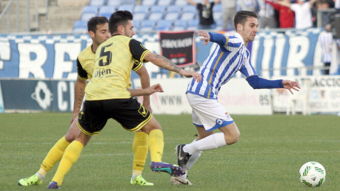 Miguelito se escapa de dos rivales durante el partido que disputó el Recre frente al Marbella en el Nuevo Colombino.