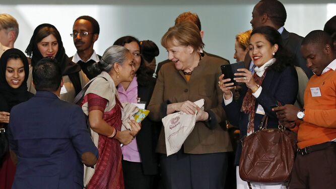 La canciller alemana, Angela Merkel, recibió ayer un regalo de una participante en el tercer Foro Internacional Alemán en la Cancillería, en Berlín.