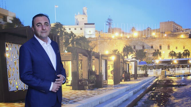 El viceconsejero de Turismo de Melilla posa frente a un cartel del puerto de la ciudad autónoma.