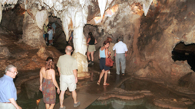 Visitantes pasean por el interior de la Gruta de las Maravillas.