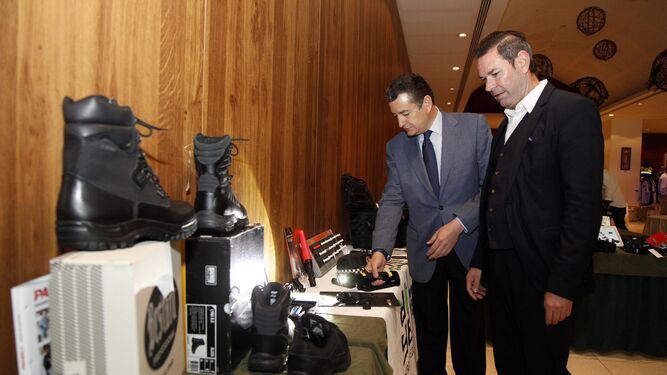 El delegado del Gobierno, Antonio Sanz, prueba una linterna entre el equipamiento policial expuesto en el congreso.