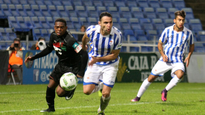Antonio Núñez se marcha de un jugador del Granada B ante la mirada de Diego Altamirano en el encuentro de la primera vuelta disputado en el Nuevo Colombino.