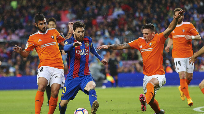 Leo Messi se deshace de los centrocampistas de Osasuna Fran Mérida y Jaime Romero que se disputó en el partido que se disputó ayer en el Camp Nou.