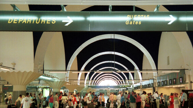 Un grupo de pasajaros hace cola para facturar sus equipajes en el aeropuerto sevillano de San Pablo.