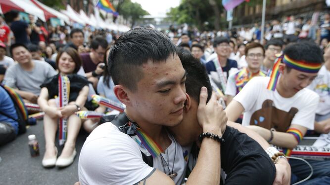 Dos taiwaneses celebran abrazos en primer plano la decisión del Tribunal Supremo ayer en Taipei.