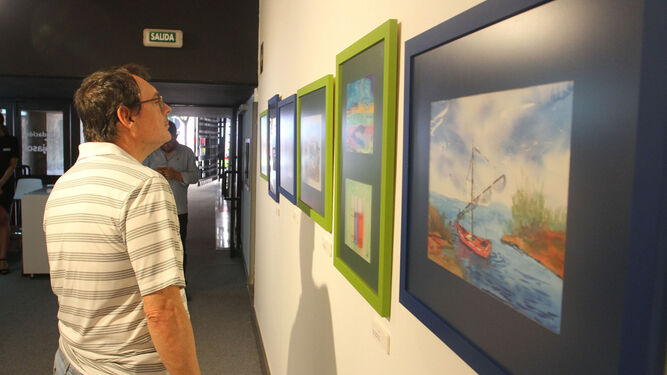 Visitantes miran con atención algunas de las obras de la exposición.