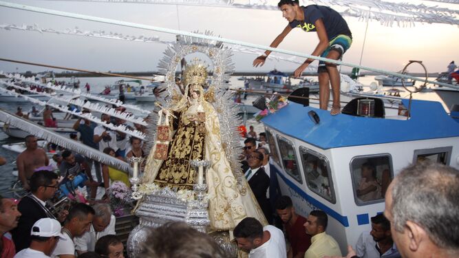 La Virgen del Carmen es subida a una embarcación para la procesión en Isla Cristina.