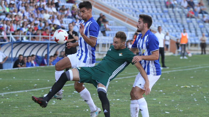 Diego Jiménez se lleva el balón ante un jugador del Betis Deportivo, en presencia de Rafa de Vicente.