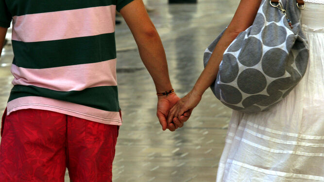 Una pareja pasea por la calle cogida de la mano. En la provincia de Huelva, 1.108 matrimonios entre personas de distinto sexo se disolvieron el pasado año.