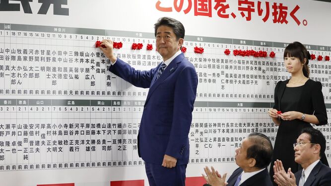Shinzo Abe coloca una rosa en nombre del PLD tras proclamar ayer su victoria en las elecciones anticipadas en Japón.