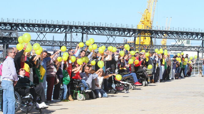 Los asistentes formaron una cadena humana en un tramo del Paseo de la Ría, mientras agitaban globos amarillos.