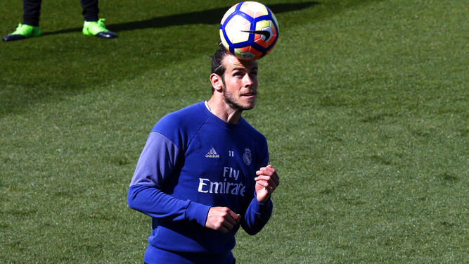 Gareth Bale controla el balón con la cabeza durante un entrenamiento del Real Madrid.