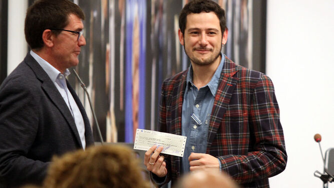 El dramaturgo Javier Hernando posa con el cheque del premio, entregado por el diputado Antonio Beltrán.