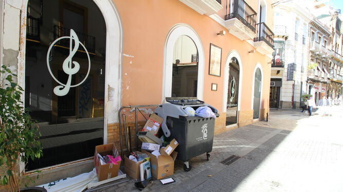Contenedor lleno de basura, con cajas amontonadas en uno de sus laterales, ayer al mediodía, en la céntrica calle Rico.