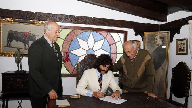 Ramón Valencia y Manolo Lozano, pendientes del momento en el que Morante estampa su firma para torear en Sevilla.