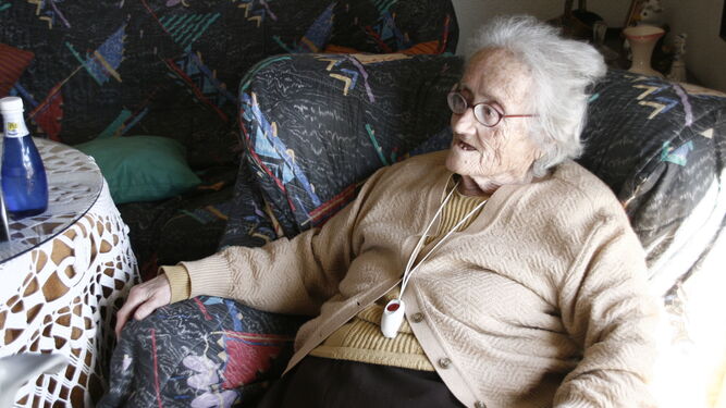 Una anciana con el dispositivo de llamada de teleasistencia