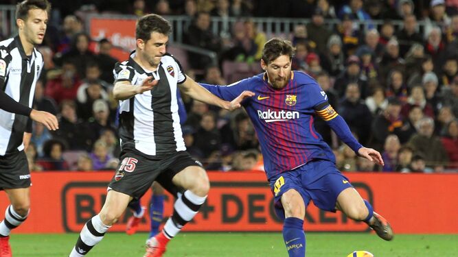 Messi se dispone a rematar ante el jugador del Levante Sergio Postigo.