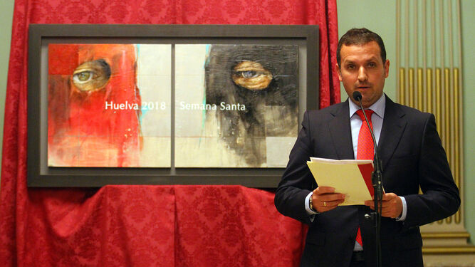 El artista Antonio Díaz Arnido, junto a su obra con la que se anunciará la Semana Santa de Huelva.
