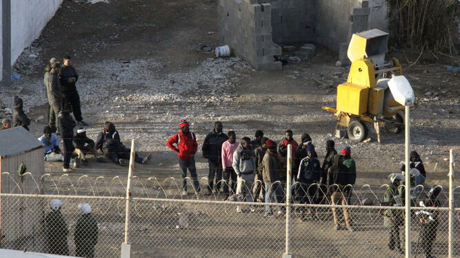 Inmigrantes  subsaharianos rodeados por la Policía marroquí, en el perímetro fronterizo entre Ceuta  y Marruecos.
