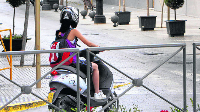 Una chica conduce un ciclomotor.