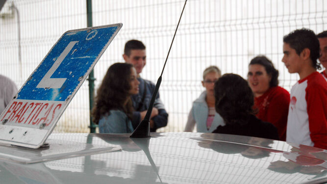 Un grupo de alumnos de una autoescuela charlan con su profesora.