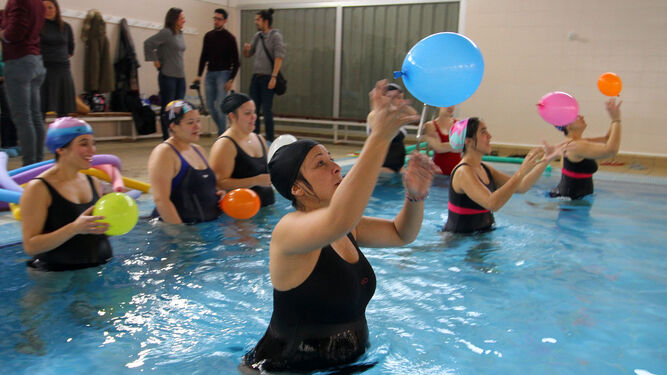 Algunas de las mujeres embarazadas que participan en el curso de preparación al parto realizan uno de los ejercicios con globos en la piscina del Polideportivo Diego Lobato.