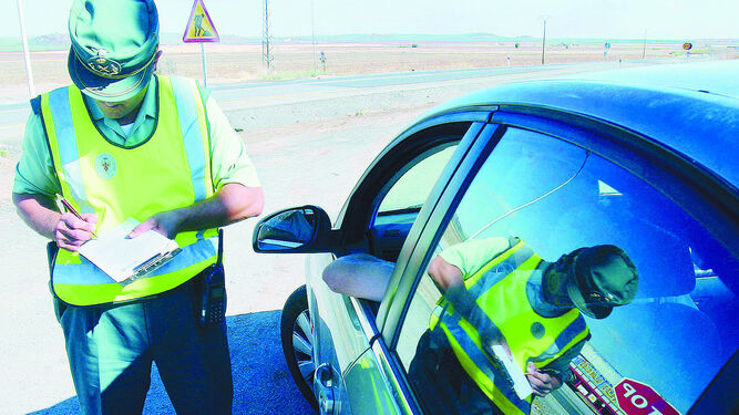 Un guardia civil de Tráfico sanciona a un conductor en un control.