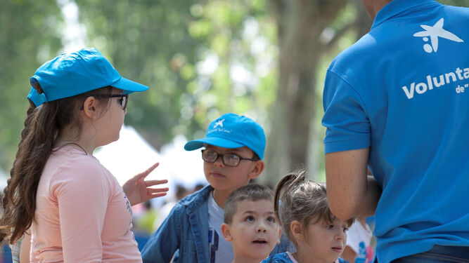 Voluntario de La Caixa con niños en una actividad de la Semana Solidaria.