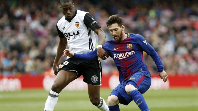 El valencianista Kondogbia intenta arrebatar el balón a Messi.