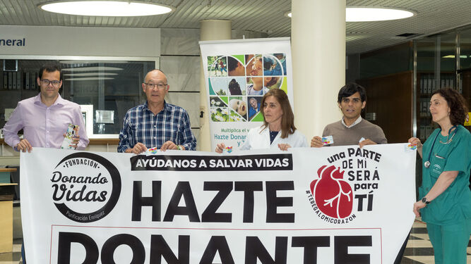 Corredores y personal del Juan Ramón posan con la pancarta promocional.