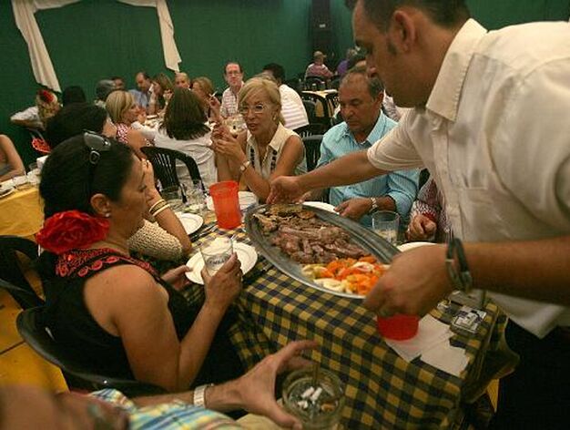 Varios comensales disfrutan del almuerzo en el interior de una caseta.

Foto: Jose Maria Qui?s
