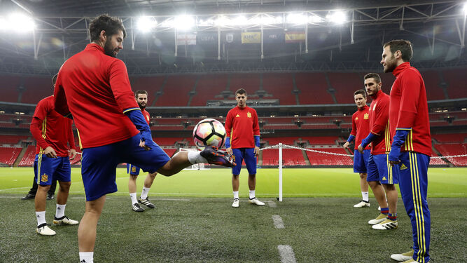 El jugador internacional Isco golpea el balón junto a sus compañeros en los prolegómenos del entrenamiento en Wembley.