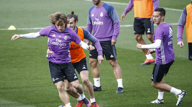 Modric conduce el balón en un entrenamiento ante la oposición del galés Bale.