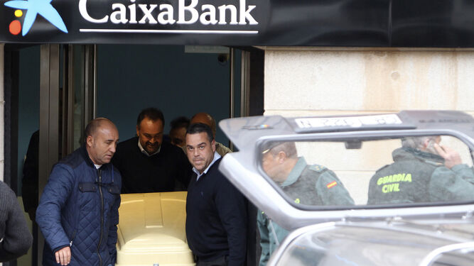 Varios miembros de los servicios funerarios trasladan ayer el cadáver del director de banco asesinado en La Solana.