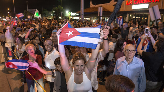 Cubanos con banderas nacionales al alza.
