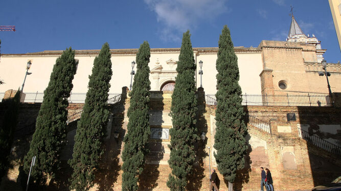 La hilera de cipreses que apuntala el muro y la propia iglesia en su visión desde el paseo de Santa Fe.