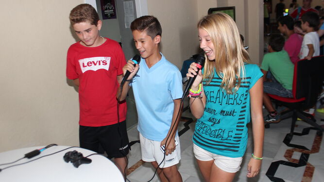 Dos niños juegan al karaoke en la Feria de Videojuegos impartida por la empresa Gamer Tech.