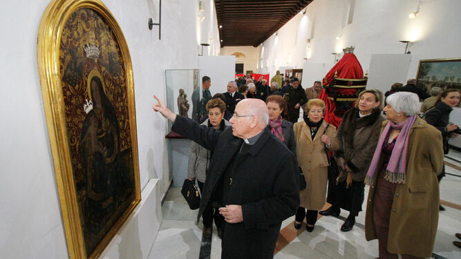 El obispo de Huelva, ante la pintura de la Virgen de la Cinta, obra de Padilla.