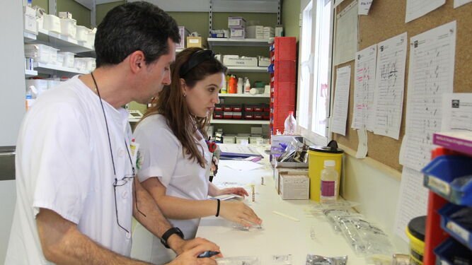 Dos enfermeros preparan tratamientos en la planta de hospitalización.