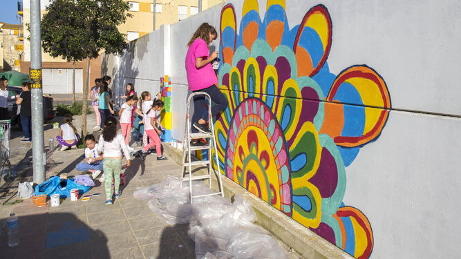 Los pequeños de la barriada onubense disfrutan con el curso de pintura. Más de una veintena de menores participan en la actividad.