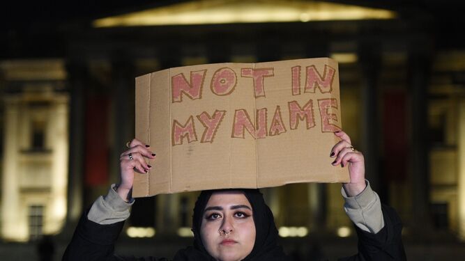 Una mujer sostiene una pancarta durante una vigilia en la céntrica plaza de Trafalgar, en Londres.