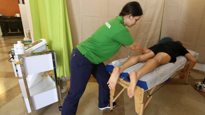 Un costalero recibe un masaje en las piernas en el Centro de Atención.